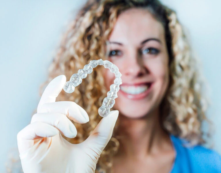 Woman holding clear aligner trays